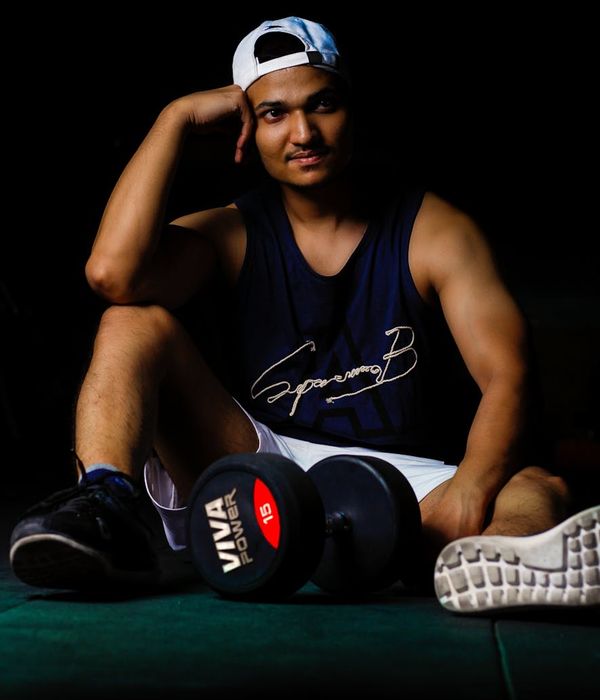 Male athlete in a focused yoga pose on a dark background.